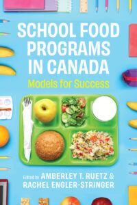 Cover: School Food Programs in Canada: Models for Success, edited by Amberley T. Ruetz and Rachel Engler-Stringer. Photo: a green lunch tray seen from above, with a fork wrapped in a napkin, salad, apple, bun, glass of milk, and rice dish. Bordering the image against a blue background are the tips of pencil crayons, rulers, notebooks, bananas, other fruits, a paint set, granola bars, books, and a pencil case.